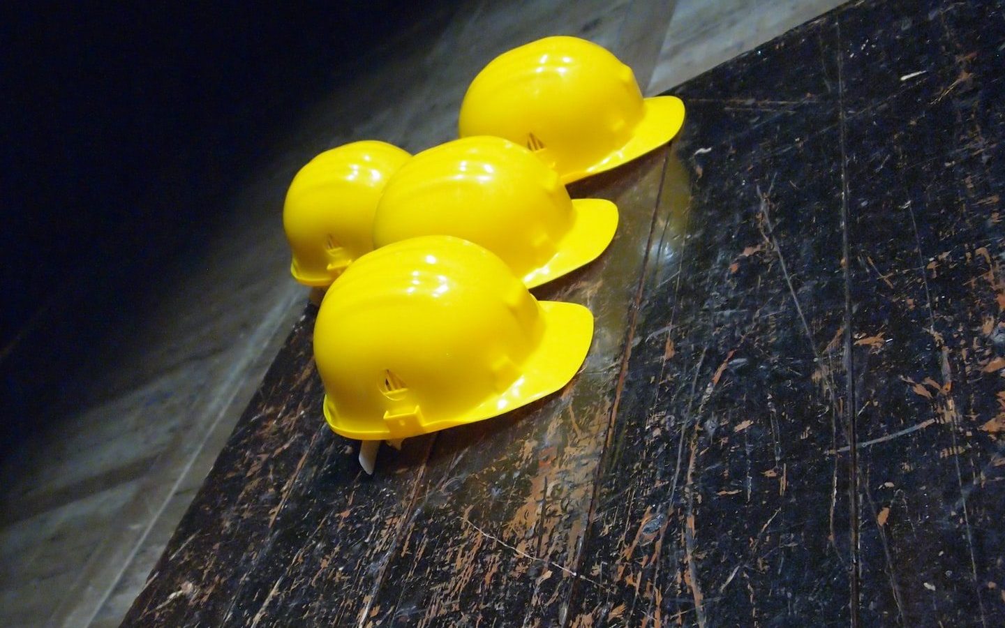 five yellow hard hats on gray surface
